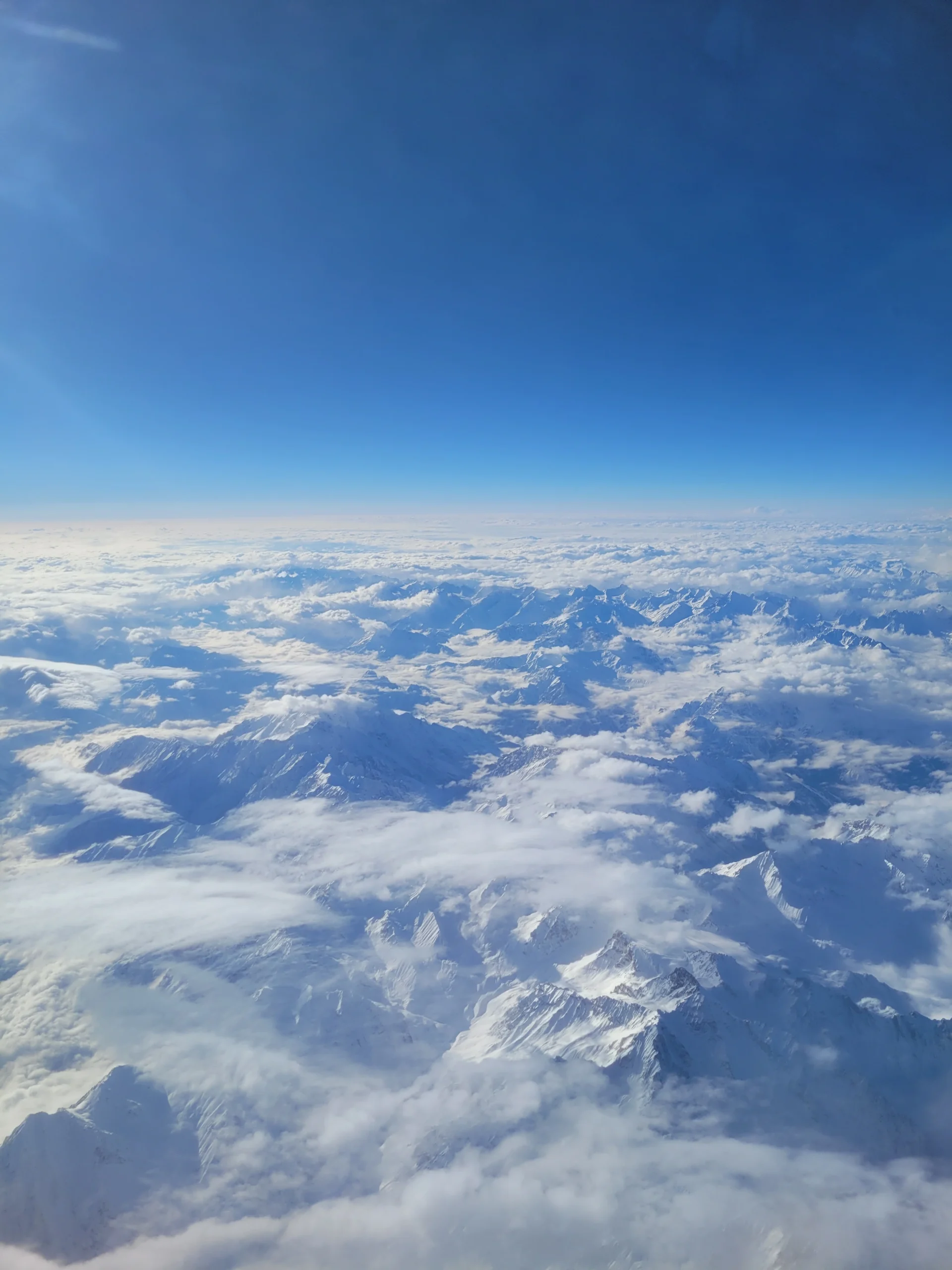 Snow covered Himalayan mountain range seen from airplane window